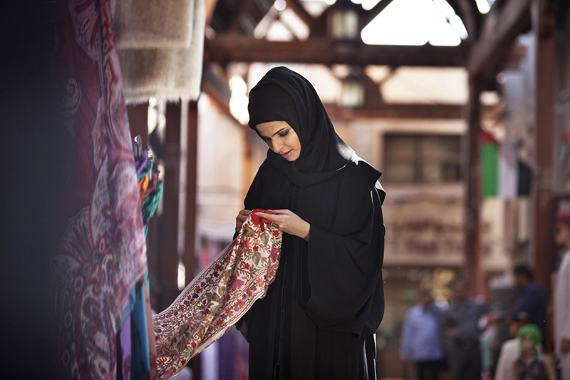 Shopping_Textile Souk_Emirati lady looking at fabric